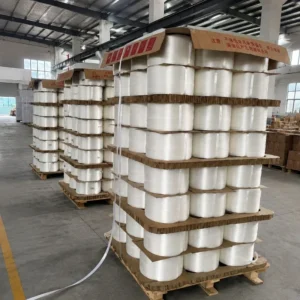 Bulk polyester composite strapping rolls stacked neatly on wooden pallets in factory warehouse
