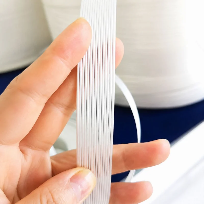 Close up detail of flexible corded polyester composite strapping thread structure held in hand